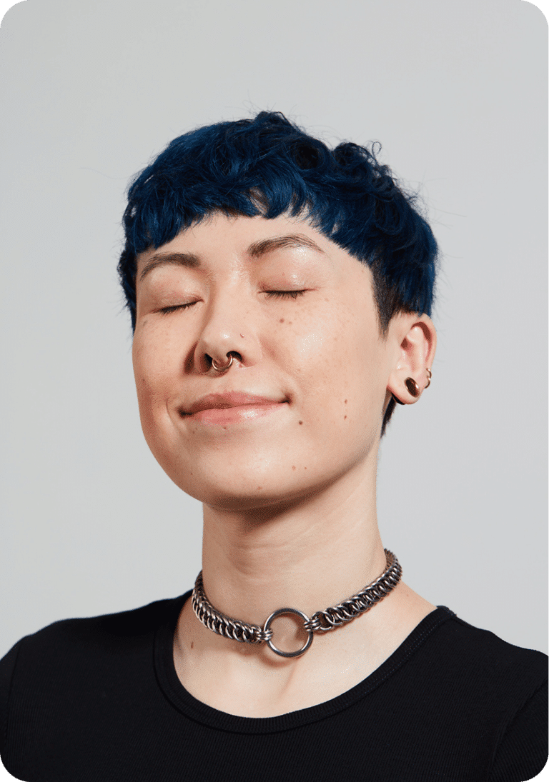 Portrait of a person with blue hair, eyes closed